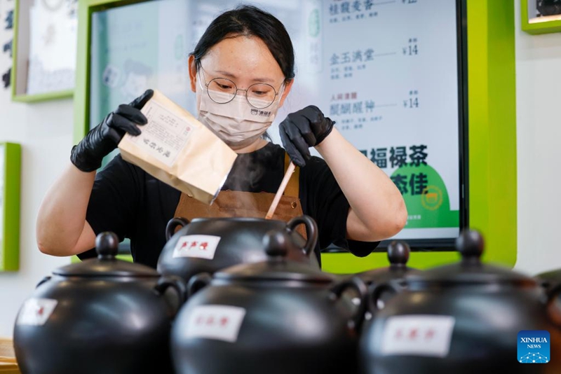 Mfanyakazi akimimina viungo kwenye vyungu ndani ya duka la vinywaji vya chai katika Mji wa Huangshan, Mkoa wa Anhui, mashariki mwa China, Aprili 22, 2026. (Picha na Shi Yalei/Xinhua)