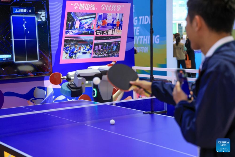 Mtembeleaji akicheza mpira wa meza na roboti kwenye Maonyesho ya 22 ya China ya Mambo ya Utamaduni ya Kimataifa huko Shenzhen, Mkoa wa Guangdong, kusini mwa China, Mei 21, 2026. (Xinhua/Mao Siqian)