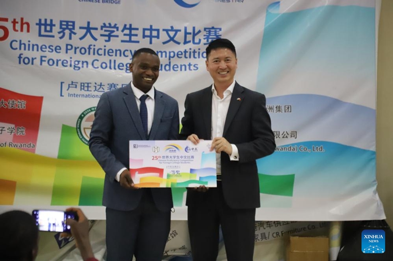 Nkurunziza Tharcisse, mshindi wa fainali ya Rwanda ya Mashindano ya Umahiri wa Lugha ya Kichina ya "Daraja la Lugha ya Kichina" ya mwaka 2026 kwa Wanafunzi wa Vyuo, akipiga picha na Gao Wenqi, Balozi wa China nchini Rwanda, mjini Kigali, Rwanda, Mei 24, 2026. (Xinhua/Liu Youmin)