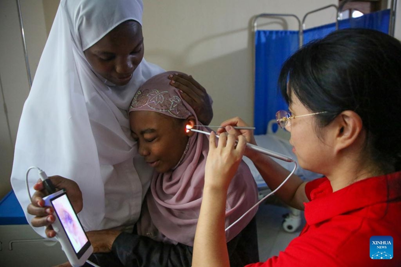 Daktari Mchina akichunguza sikio la binti mwenyeji, Zanzibar, Tanzania, Mei 30, 2026. (Xinhua/Emmanuel Herman)