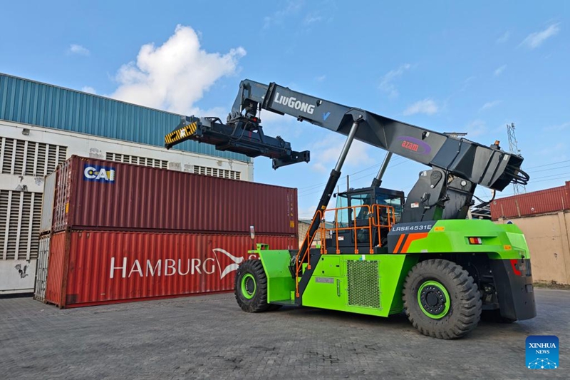 Picha hii ikionyesha mashine ya umeme inayokabidhiwa hivi karibuni ya kuinua na kupanga mizigo iliyoundwa China ikiinua kontena jijini Dar es Salaam, Tanzania, Juni 1, 2026. (Xinhua/Lin Guangyao)