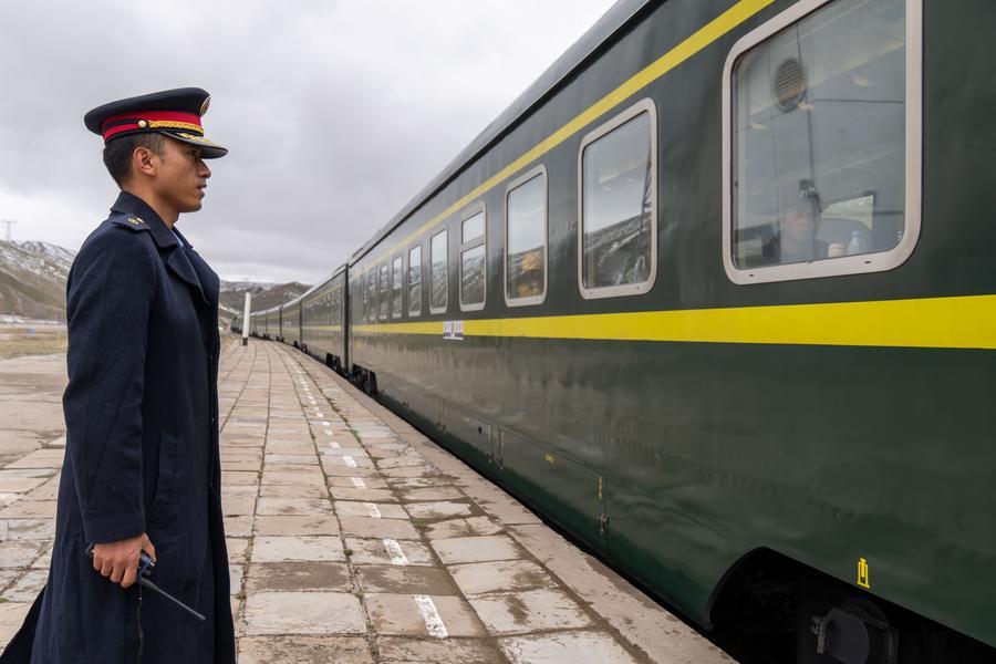 Sangye Phuntsok, mfanyakazi wa kituo cha reli ya Yanshiping, akisindikiza treni iliyokuwa inaondoka katika Wilaya ya Amdo ya Nagqu, Mkoa unaojiendesha wa Xizang, kusini-magharibi mwa China, Juni 10, 2026. (Xinhua/Tenzing Nima Qadhup)