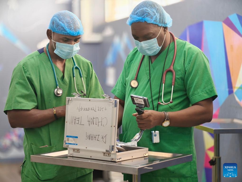 Madaktari wa ganzi wenyeji wakikagua sanduku la vifaa tiba lenye maandishi ya mkono ya jina na namba ya simu ya marehemu daktari Mchina Zhang Junqiao katika Hospitali ya Taifa ya Muhimbili jijini Dar es Salaam, Tanzania, Mei 29, 2026. (Xinhua/Ding Ting)