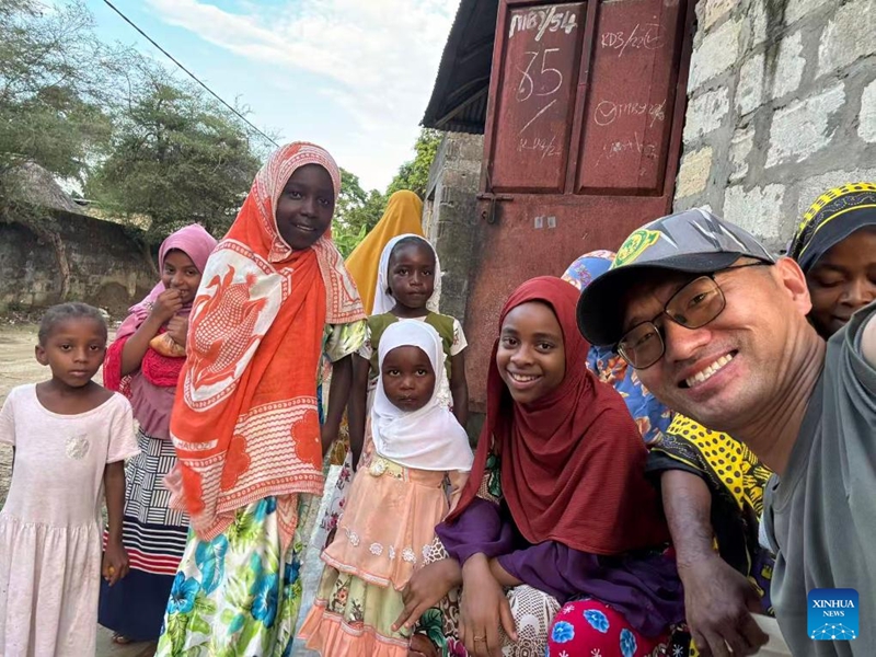 Daktari Mchina marehemu Zhang Junqiao akipiga picha na watoto wenyeji, Zanzibar, Tanzania, Desemba 26, 2024. (Xinhua)