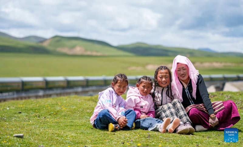 Tatso (wa kwanza kulia) na binti zake watatu wakipiga picha mbele ya nyumba yao pembeni ya Reli ya Qinghai-Xizang katika Wilaya ya Damxung ya Lhasa, Mkoa Unaojiendesha wa Xizang, kusini magharibi mwa China, Juni 21, 2026. (Xinhua/Tenzin Nyida)