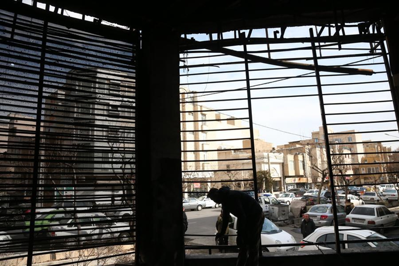 Jamaa akiwa amesimama ndani ya jengo la tawi la benki lililoharibiwa wakati wa machafuko ya hivi karibuni mjini Tehran, Iran, Januari 21, 2026. (Xinhua/Shadati)
