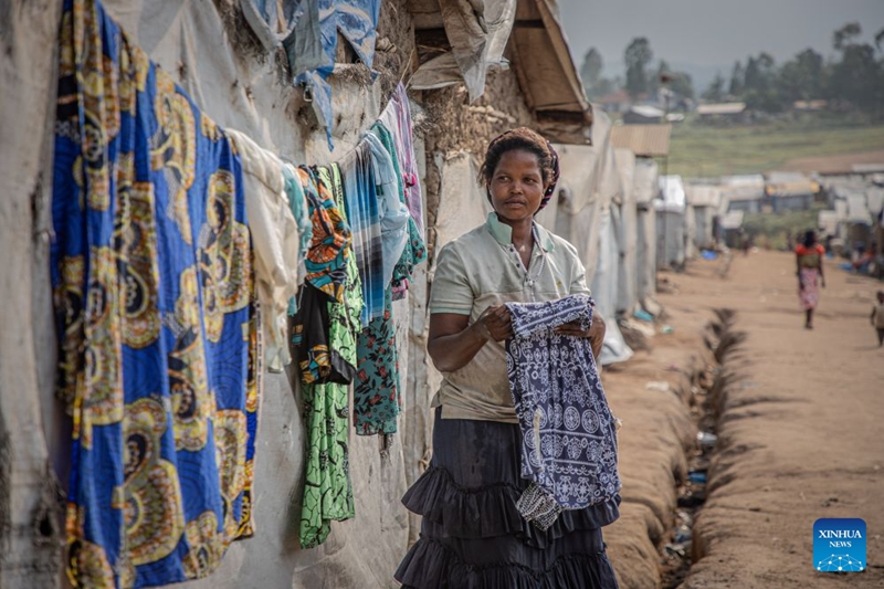 Mwanamke akitundika nguo kwenye kambi ya watu waliokimbia makazi yao karibu na Bunia, Jimbo la Ituri, Jamhuri ya Kidemokrasia ya Kongo (DRC), Julai 4, 2026. (Xinhua)