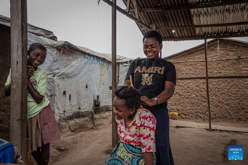 Mwanamke akimsaidia mwanamke mwingine kusuka nywele kwenye kambi ya watu waliokimbia makazi yao karibu na Bunia, Jimbo la Ituri, Jamhuri ya Kidemokrasia ya Kongo (DRC), Julai 4, 2026. (Xinhua)