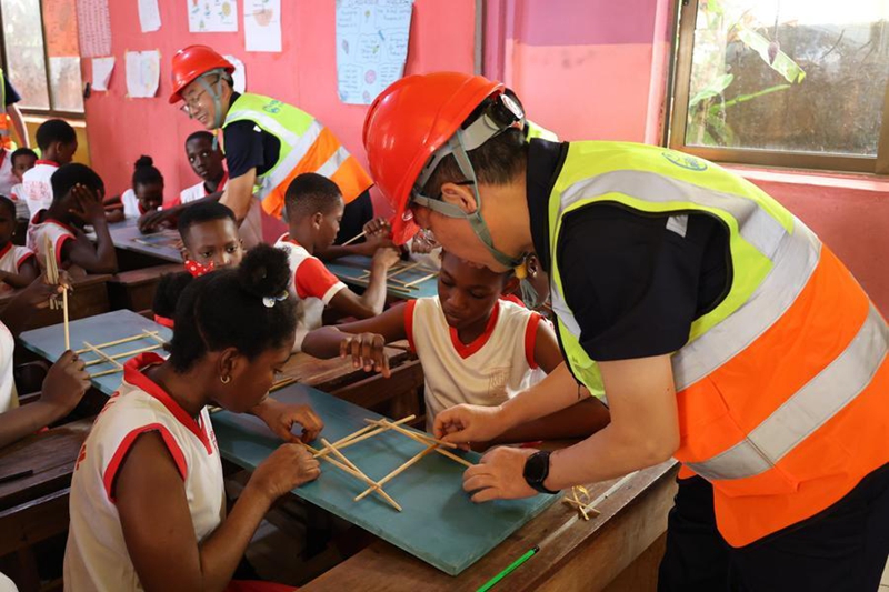 Wahandisi kutoka Kundi la Uhandisi No.5 la Shirika la Reli la China (CR5) nchini Ghana wakifundisha wanafunzi namna ya kutumia vijiti kujenga daraja kwenye shughuli ya mawasiliano ya kitamaduni katika Shule ya Kimataifa ya Zenaddo, huko Accra, Ghana, Julai 10, 2026. (Picha na Seth/Xinhua)