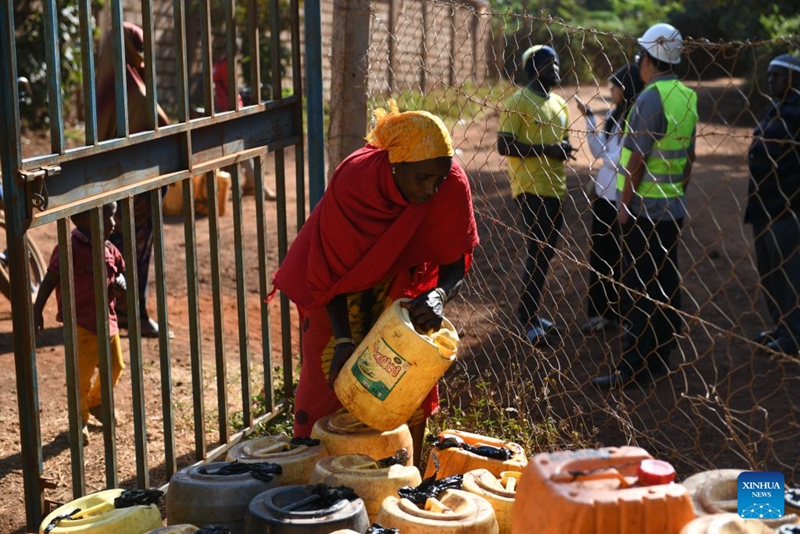 Mkazi mwenyeji akijaza vyombo vya maji kwenye sehemu ya kuchotea maji ya umma iliyojengwa na Kampuni ya Ujenzi wa Umeme ya China, Marsabit, Kenya, Julai 14, 2026. (Xinhua/Liu Qiong)