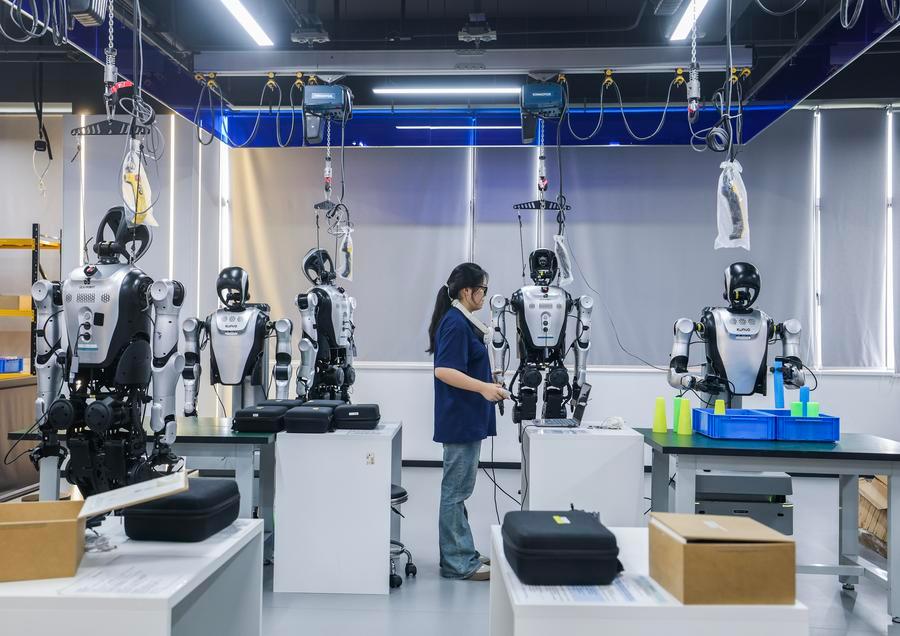 Mfanyakazi akiifundisha roboti ya umbo la binadamu kuchanganua na kupanga tyubu za uzi kwenye kituo cha kuzifanyia mafunzo roboti za umbo la binadamu katika Mji wa Cixi mkoani Zhejiang, mashariki mwa China, Septemba 3, 2026.(Xinhua/Xu Yu)