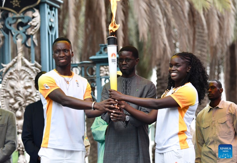 Rais wa Senegal Bassirou Diomaye Faye (katikati) akiwa ameshika mwenge kwenye hafla ya kuupokea mwenge wa Olimpiki ya Vijana kwa ajili ya Michezo ya Dakar 2026 nje ya Ikulu ya Rais jijini Dakar, Senegal, Septemba 12, 2026. (Picha na Papa Demba Gueye/Xinhua)